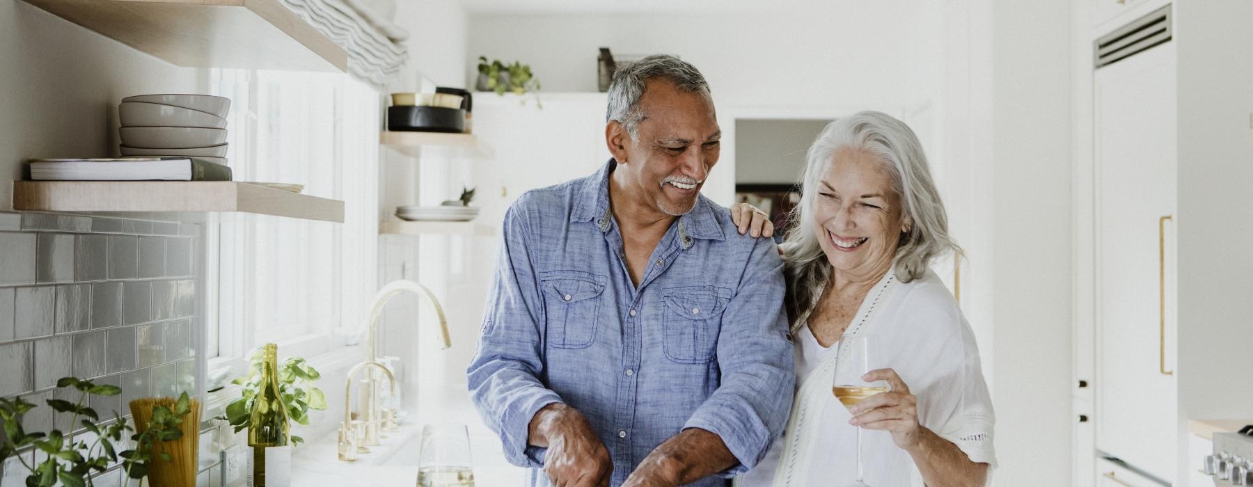 a man and a woman smiling in the kitchen